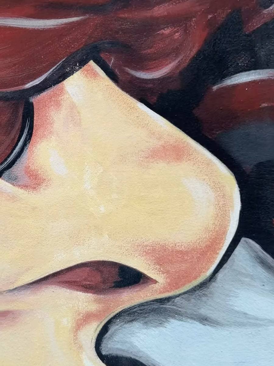 Close-up of a mural: a woman’s face with deep-red curly hair.